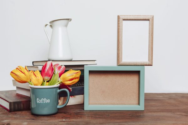 mug-with-flowers-near-frames-books